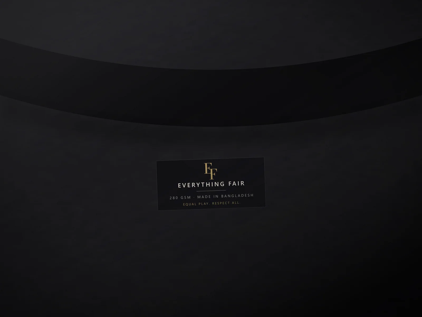 Woven Everything Fair neck label stitched inside the collar of an onyx T-shirt